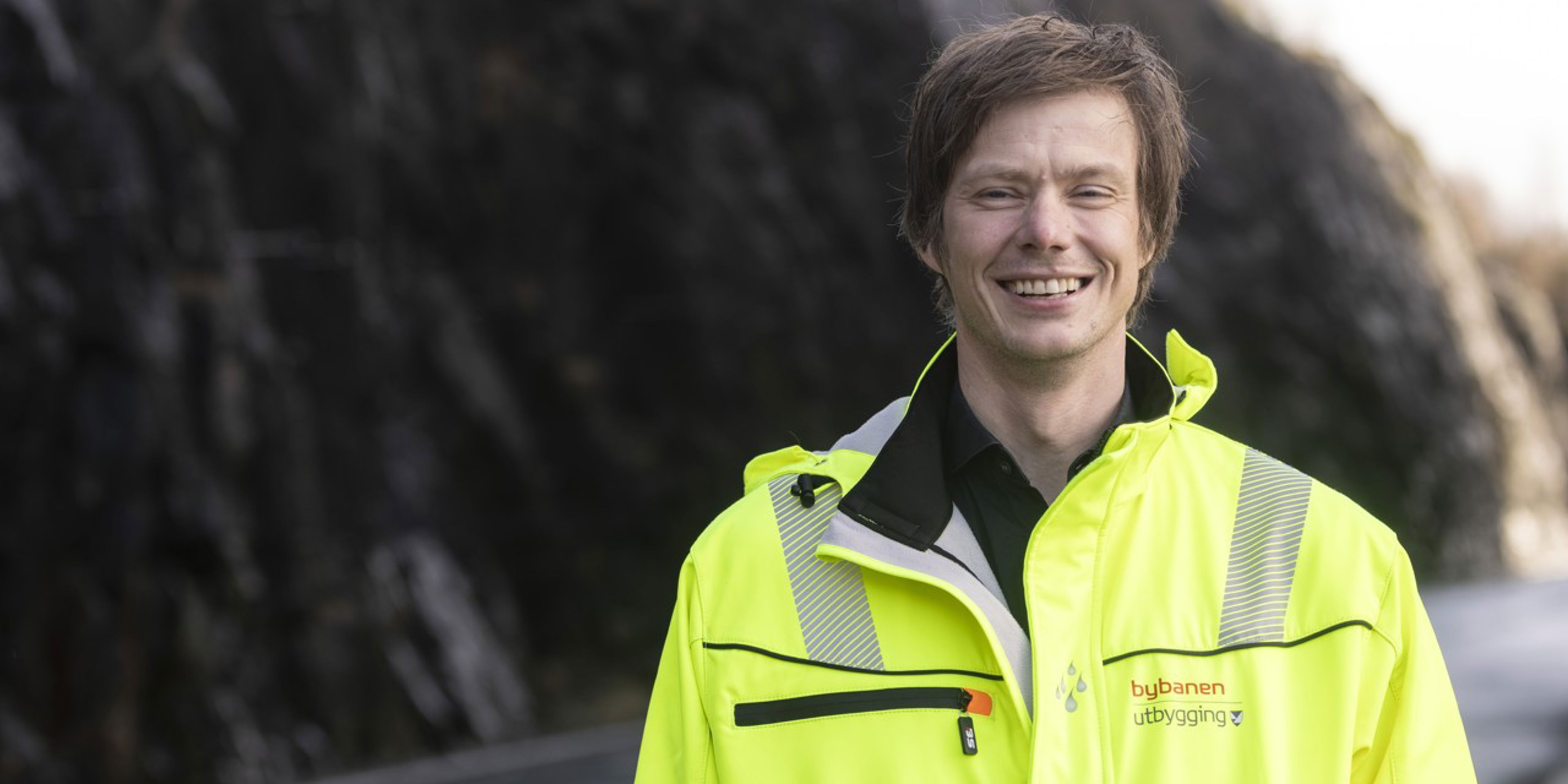 Bildete synes ein mann som msiler med gul jakke på seg