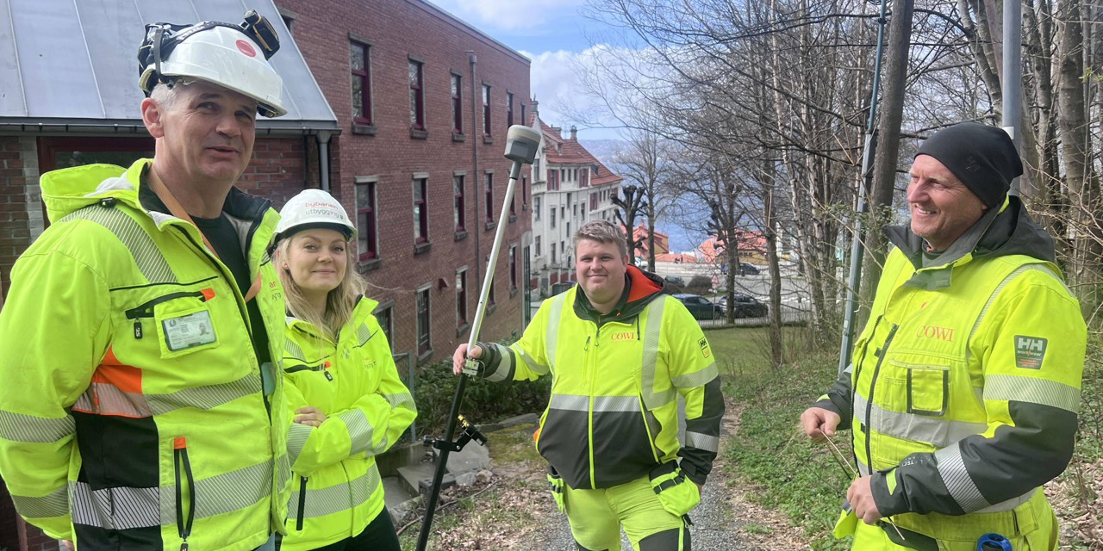 Bilete av fire fagpersonar i gule verneklede rå Bybanen Utbygging på synfaringar i Sandviken.