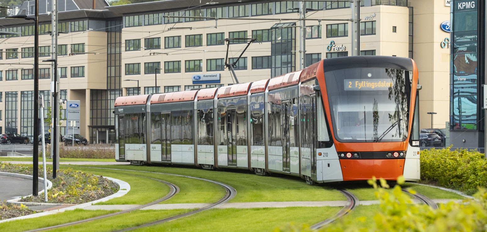 Bilete synes ei eldre kvinne med eit ung barn som kikkar ut gjennom vindauget frå bybanen i Bergen