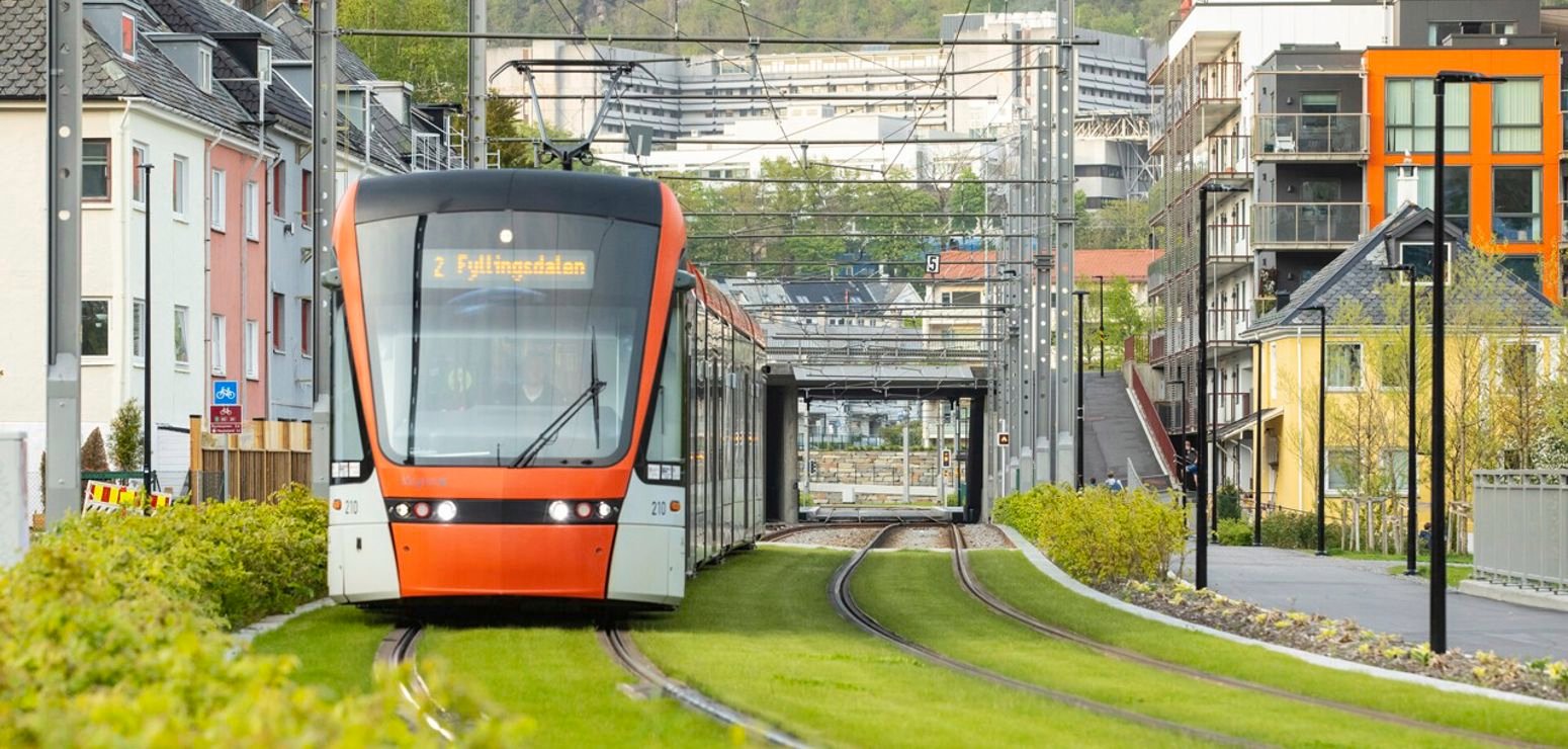 Biletet syner Bybanen i Bergen i sporet frå Kronstad til Mindemyren på linje 2 til Fyllingsdalen. I sporet er det grønt gras.