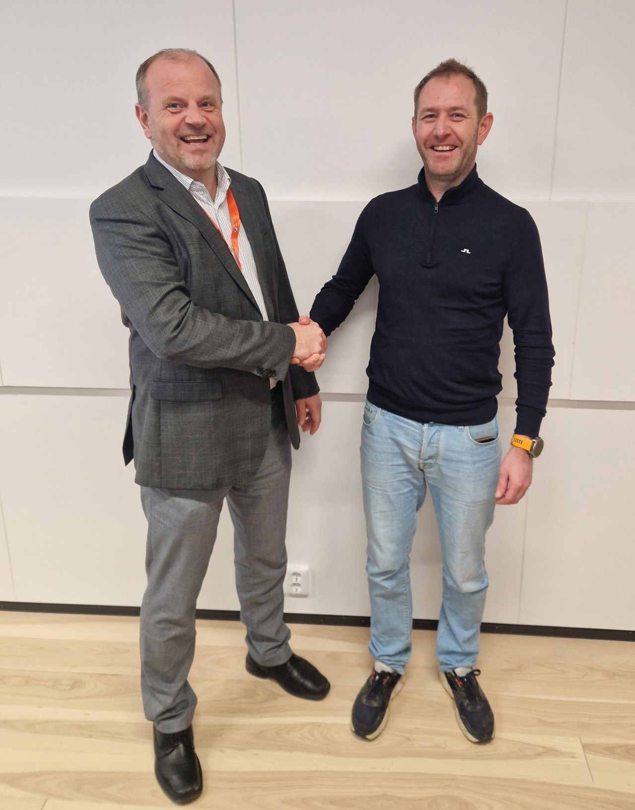 Bilete tyder to personer som held kverandre i hånda etter signering av ei rammeavtale. Personene er Arve Tjønn Rinde og Tore Sælen